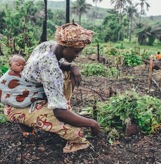 women carrying baby in her back close-up photography