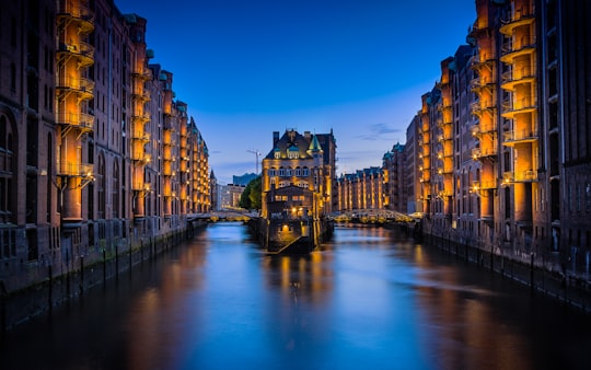 canal between buildings during nighttime in Speicherstadt Germany