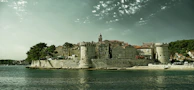 Historic stone buildings lining a charming seaside village along the Adriatic.