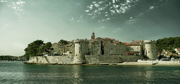 Historic stone buildings lining a charming seaside village along the Adriatic.