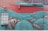 A vibrant and intricate mural decorates a red brick wall, featuring a large fish eye peering through ornate teal and turquoise patterns. These patterns flow across the wall, incorporating elements that suggest tentacles or waves. A large window and a red garage door are integrated into the artwork.