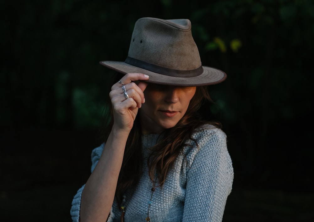 mujer en suéter azul sosteniendo su sombrero