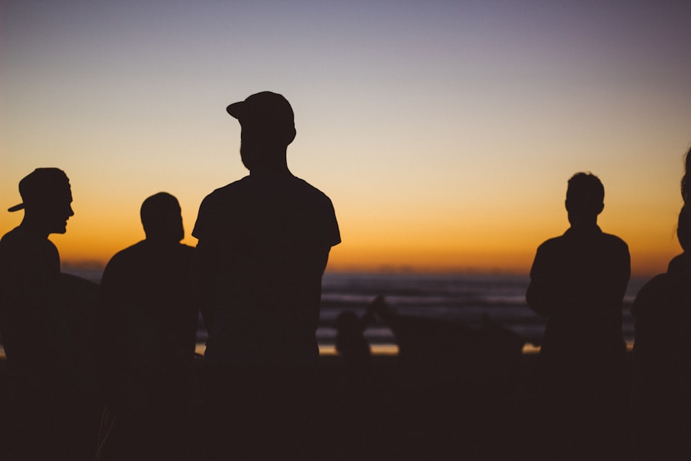 gruppo di silhouette di persone sotto il tramonto