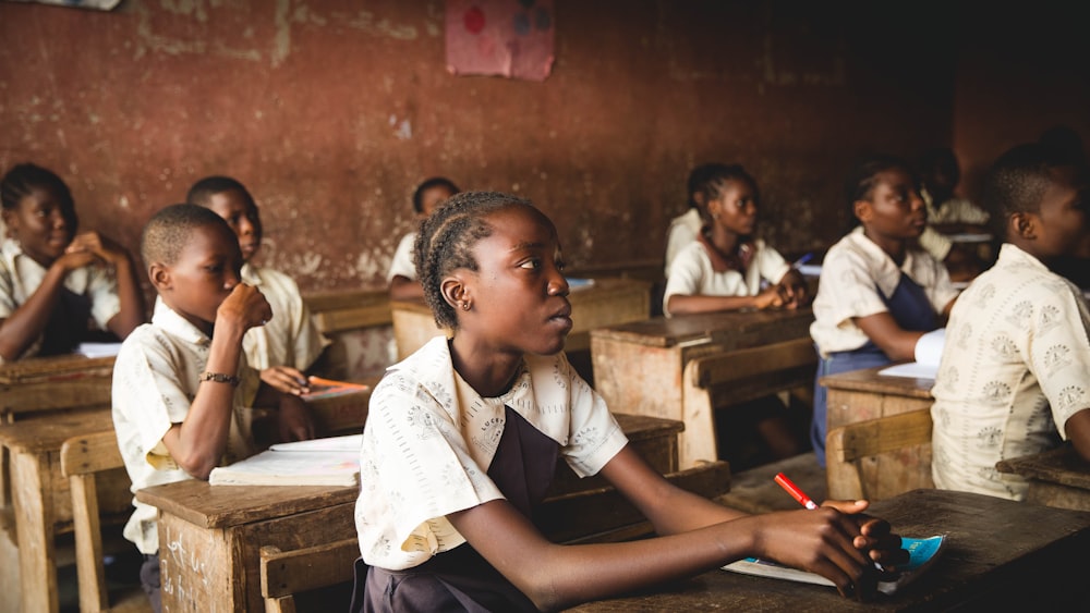 children sitting on chairs inside classroom