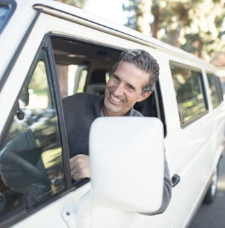 man in gray sweater leaning on van window