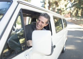 man in gray sweater leaning on van window