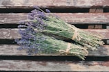 Close-up of fresh lavender sprigs resting on rustic wooden table.