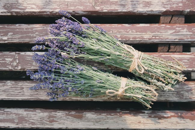 Close-up of fresh lavender sprigs resting on rustic wooden table.