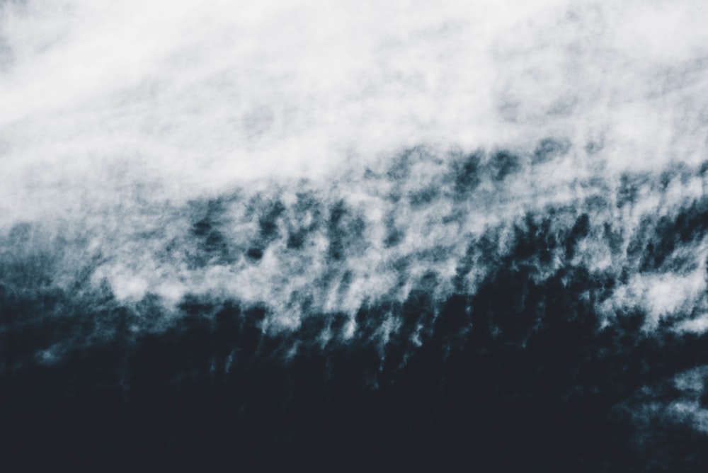 a black and white photo of a plane flying in the sky