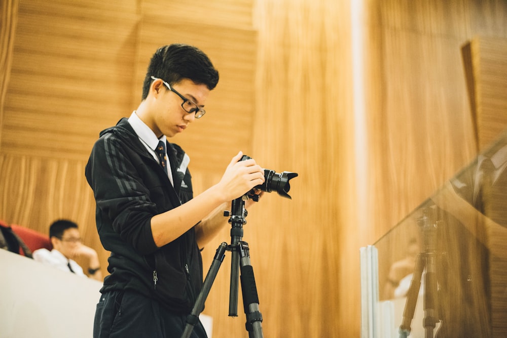 hombre sosteniendo una cámara DSLR