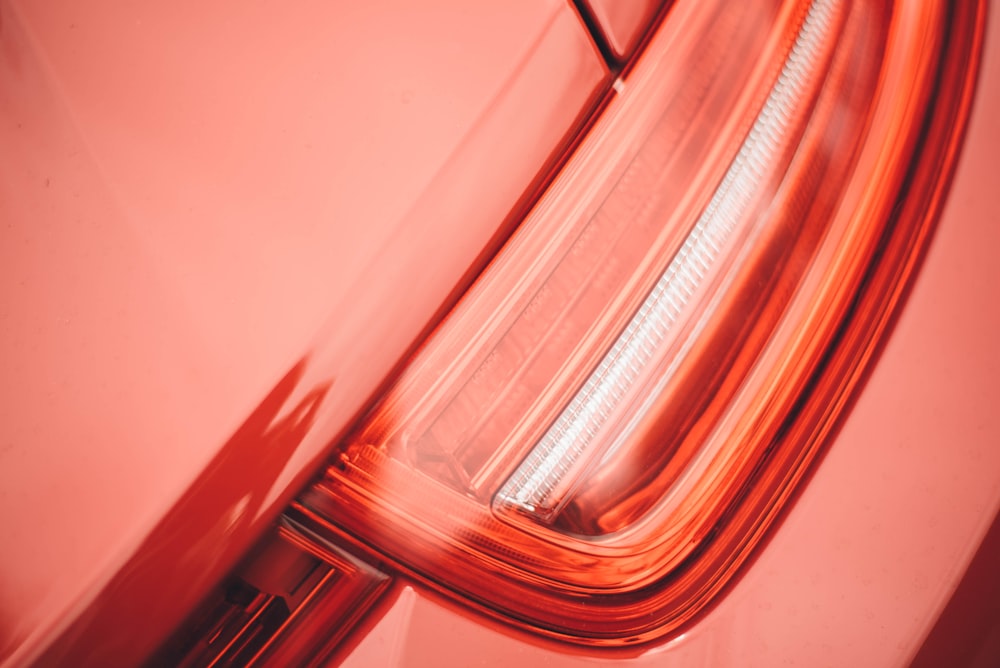 Prise de vue macro du feu arrière d’une voiture rouge.