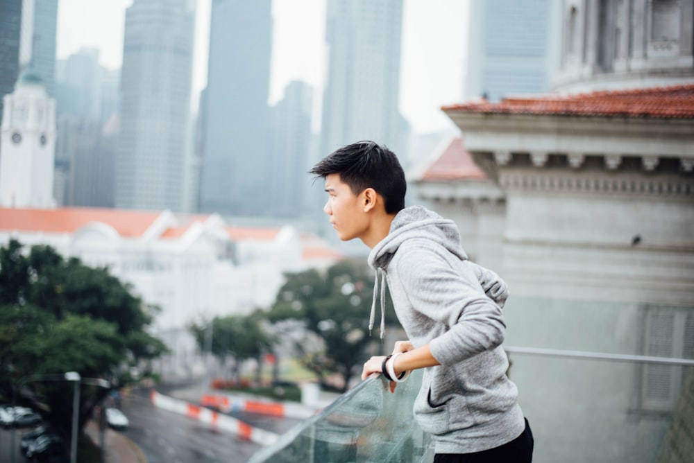 man standing near glass fence