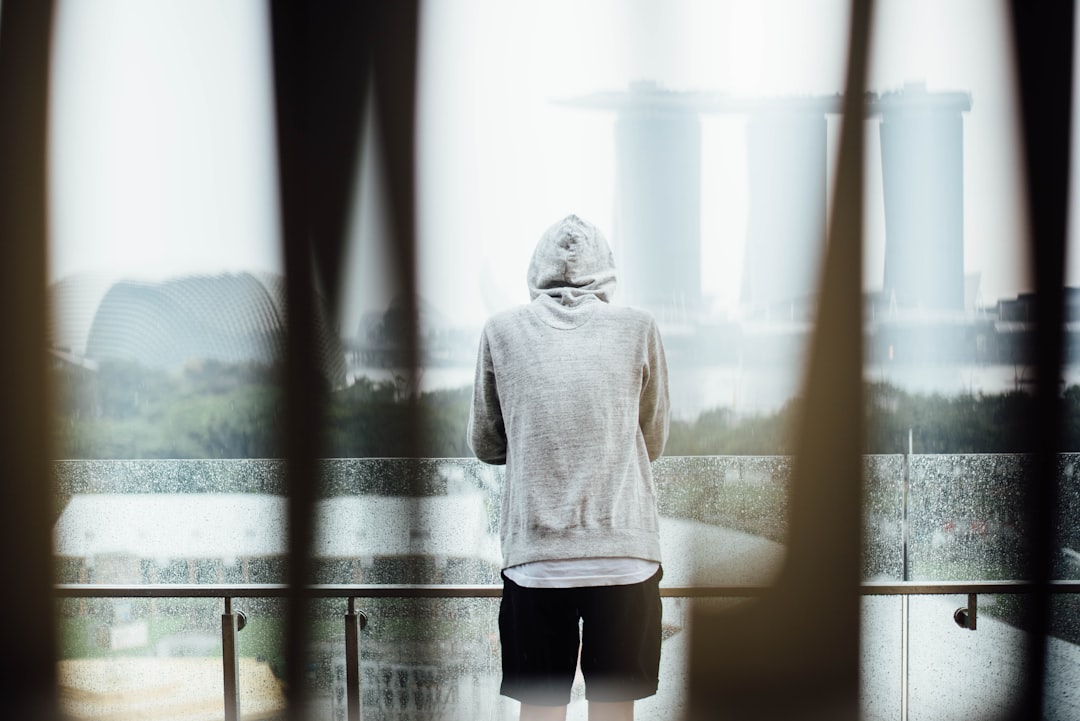 woman in hooded jacket standing at terrace