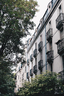 Exterior view of a residential building with balconies and greenery