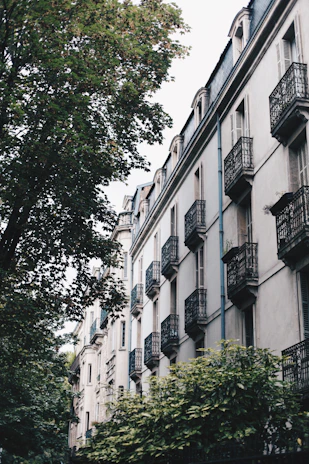 Exterior view of a well-maintained residential building with balconies and greenery.