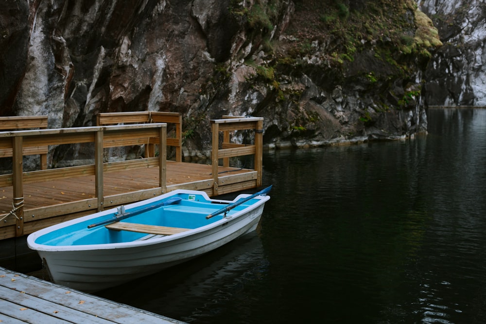 white and blue boat on dock