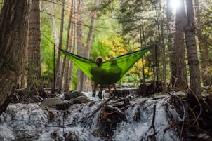 two person on green mesh hammock outdoor
