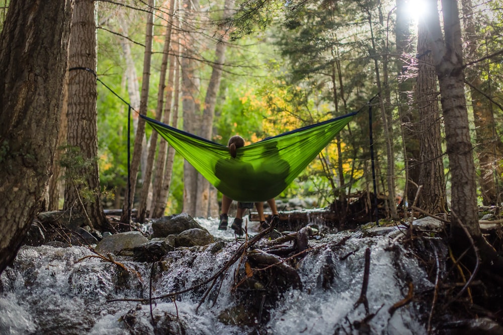 Dos personas en hamaca de malla verde al aire libre