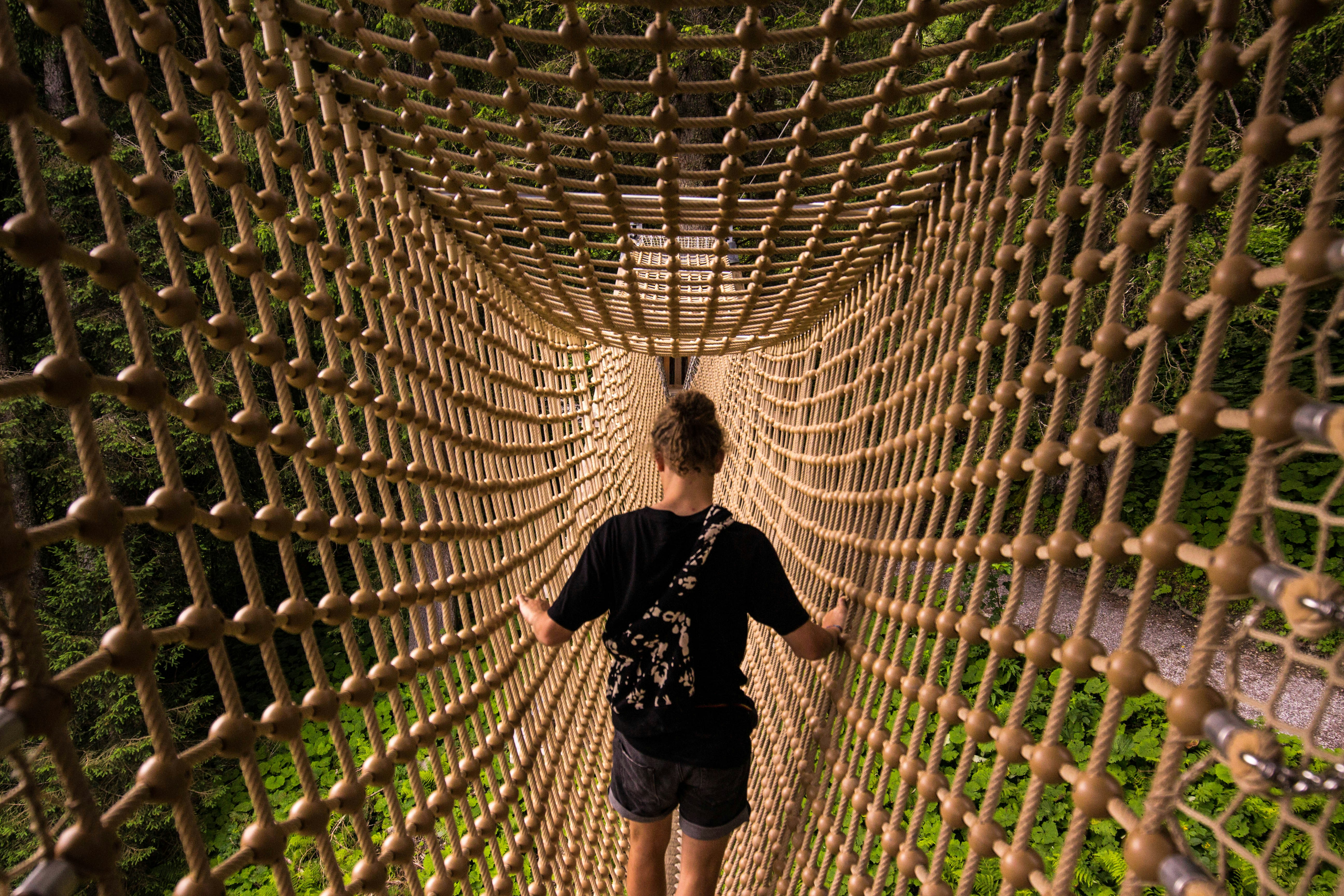 man in black and white crew neck t-shirt and black shorts standing on brown wooden