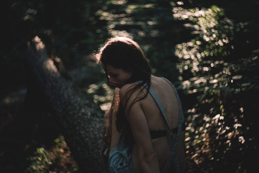 Fotografía de primer plano de mujer sentada frente al cuerpo de agua