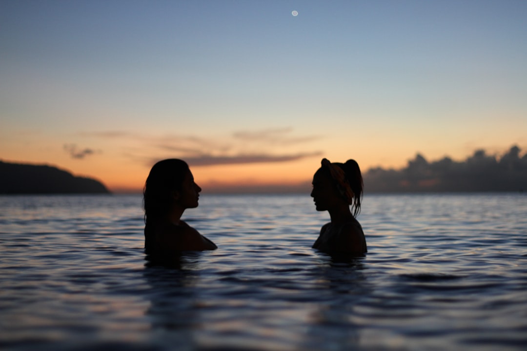 Two women ocean sunset