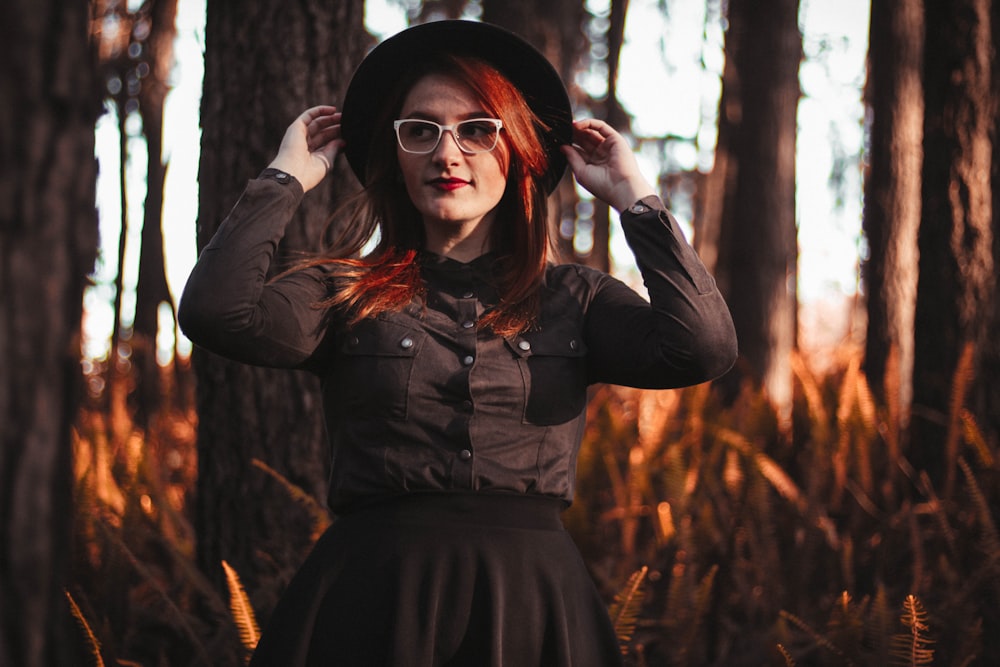 a woman with red hair wearing a hat and glasses