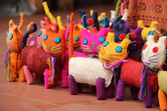 Cute cats wearing vibrant handmade dresses and accessories in a cozy indoor setting