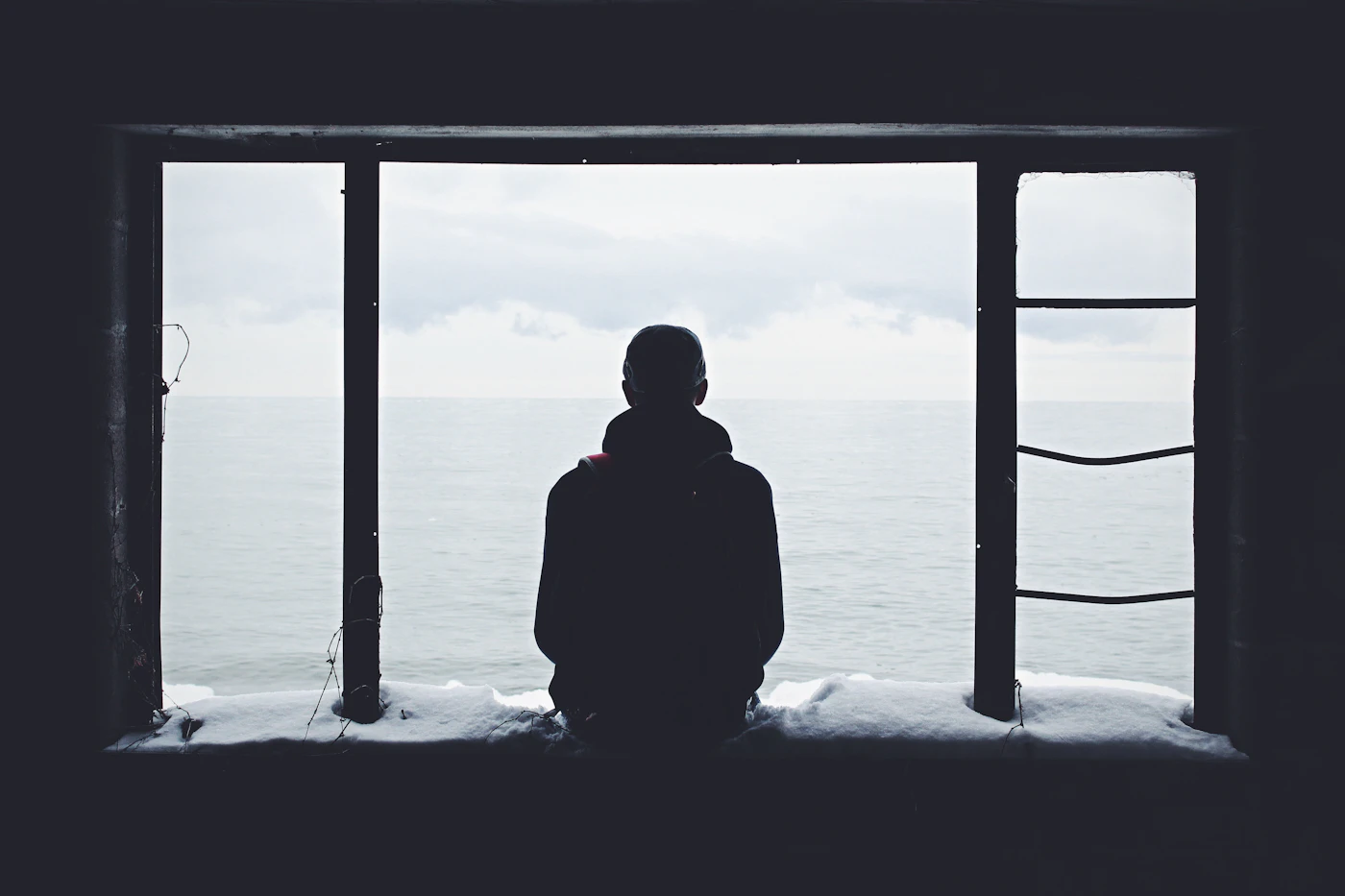 A young professional sitting quietly by a window, the kind of unhurried personal moment a coaching conversation creates space for