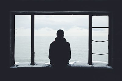 A person sitting alone, gazing out at the sea