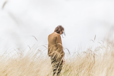 person standing in the middle of wheat field neutral teams background