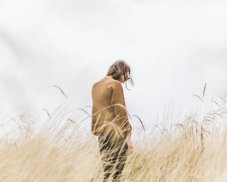 person standing in the middle of wheat field by Matthew Henry (@matthewhenry)