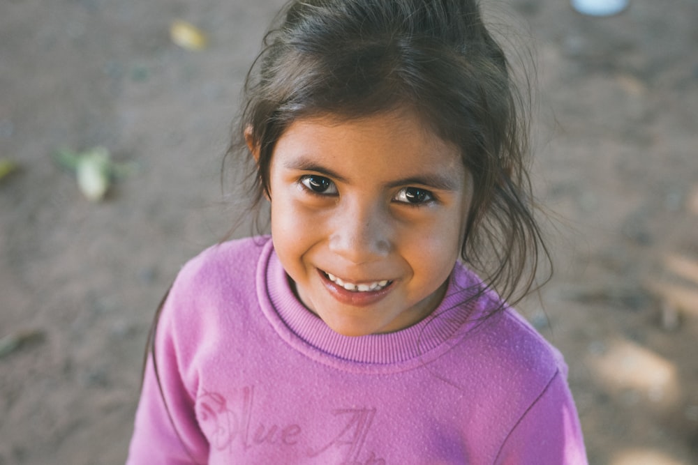 menina na camisa cor-de-rosa do pescoço da tripulação