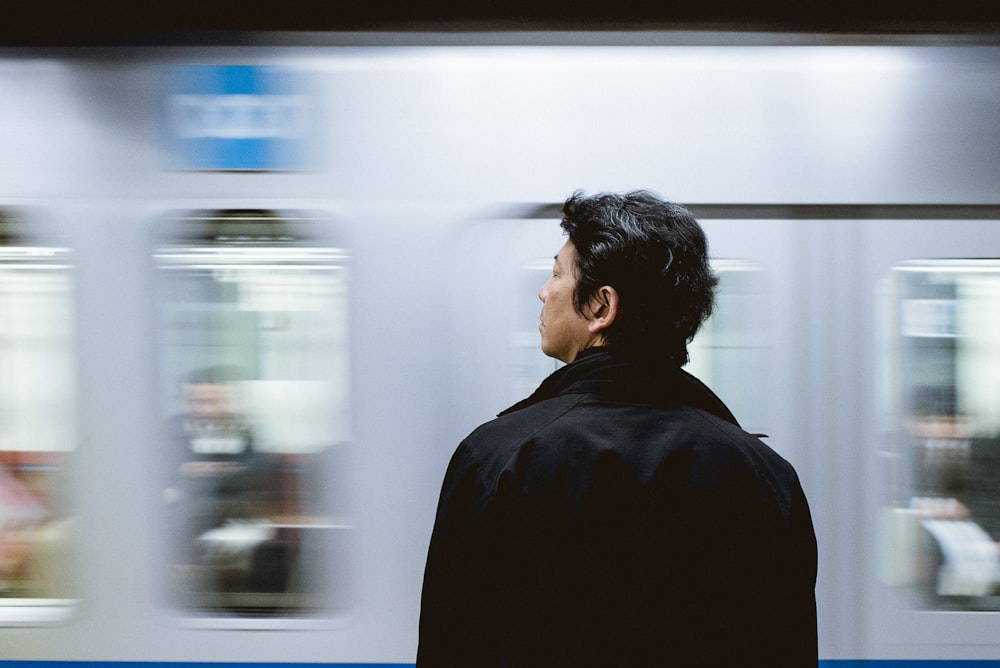close-up photography of man standing front of train