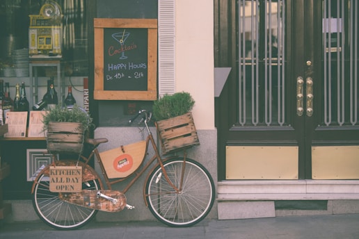 brown city bicycle near brown wooden door