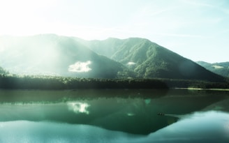 A serene landscape with a person meditating near a calm lake.