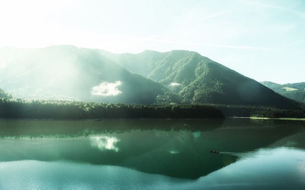A serene landscape with a person meditating near a calm lake.