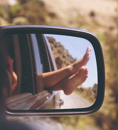 person's leg resting on vehicle window