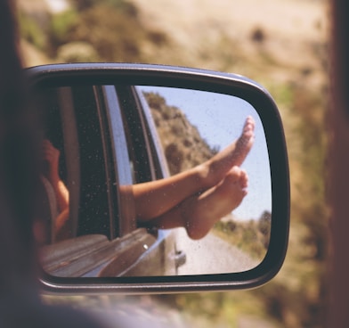 person's leg resting on vehicle window