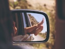 person's leg resting on vehicle window