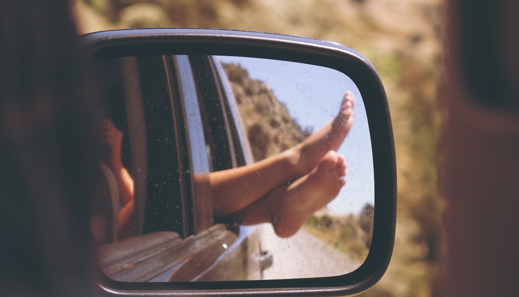 person's leg resting on vehicle window