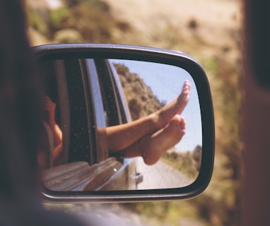 person's leg resting on vehicle window