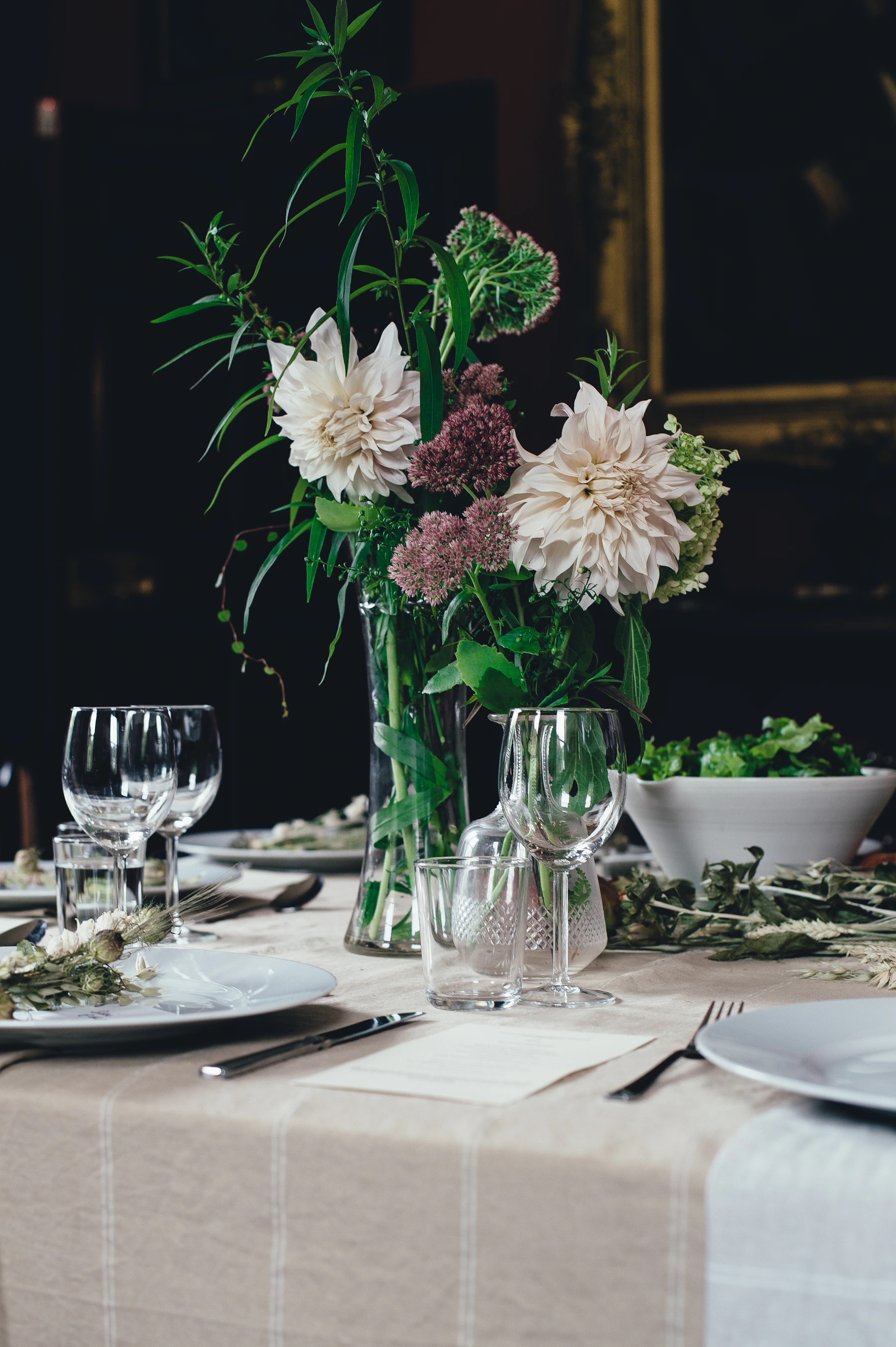 Elegant dining table with plates glassware flatware and flowers