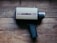 A vintage Super 8 movie camera sits on a wooden surface. The camera has a tan body with a label reading 'argus 806' and 'super eight.' It features a black handle and a textured focus ring on the lens.