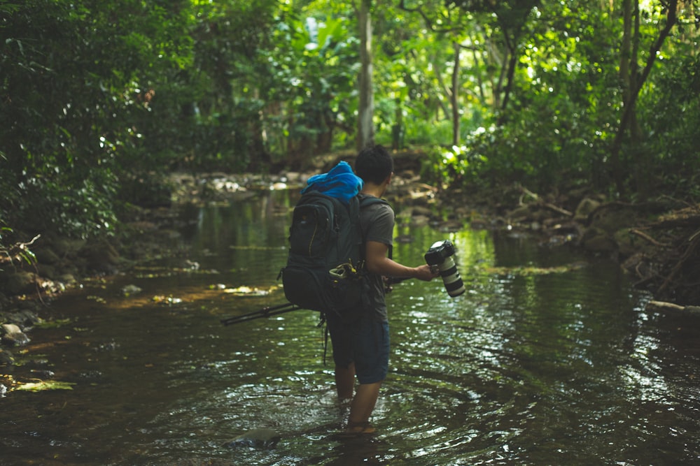 shallow focus photography of man walking in river