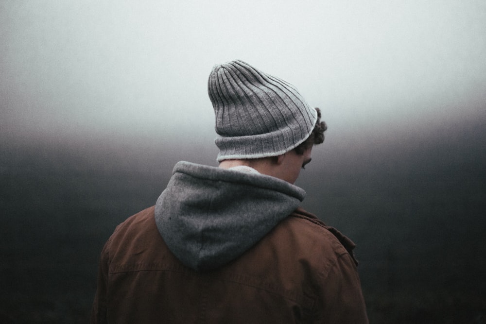 man wearing knit cap on grey background