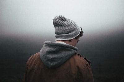 man wearing knit cap on grey background concerned google meet background