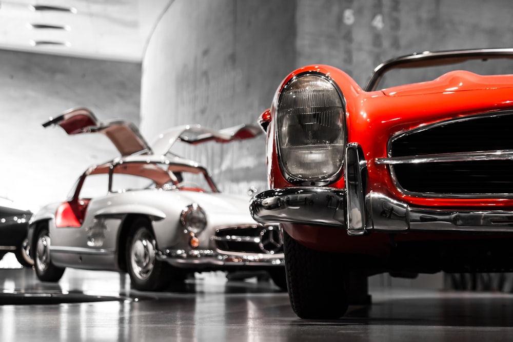 two vintage cars beside gray concrete wall