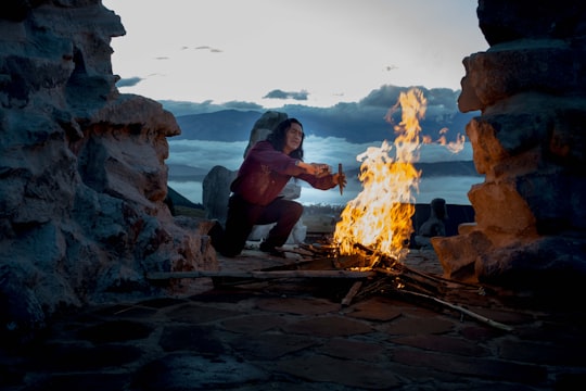 person kneeling in front of bonfire outside in Quito Ecuador