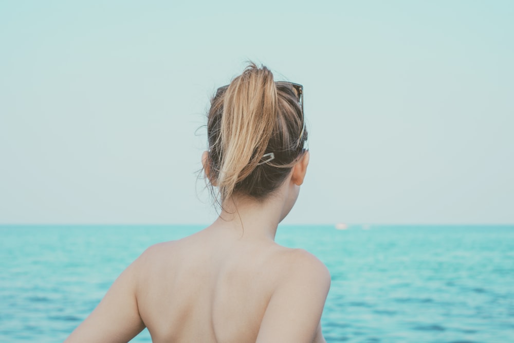 mulher olhando para o mar durante o dia