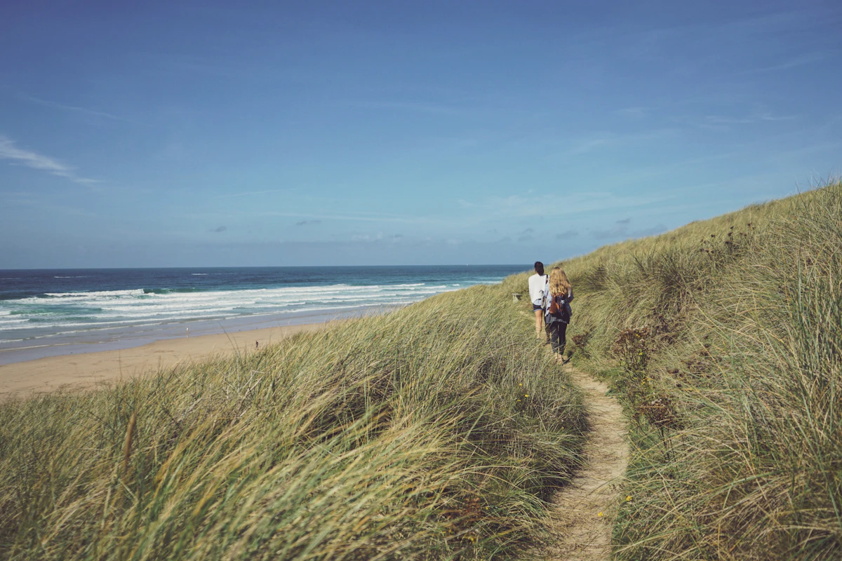 A sandy path through dune grass above the beach at Perranporth